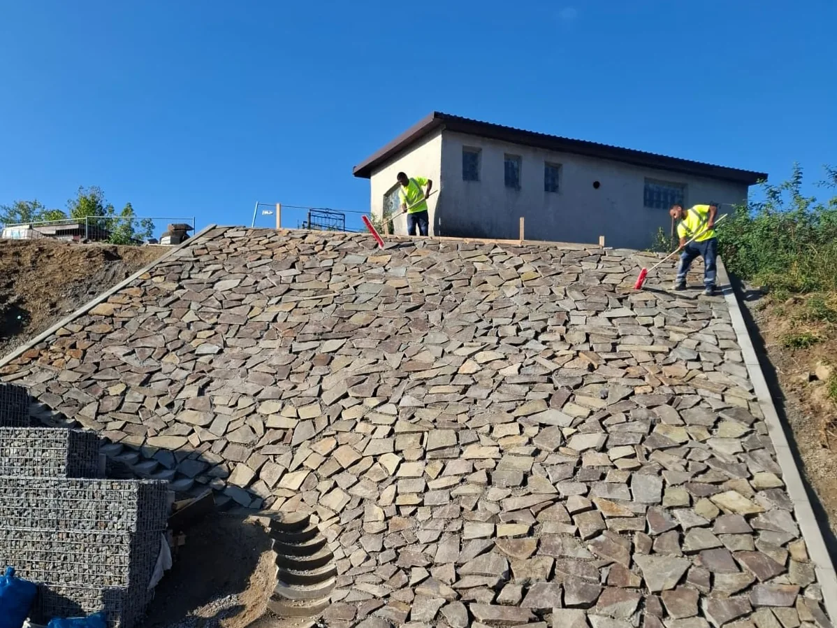 Kamenná dlažba svahu okolo objektu